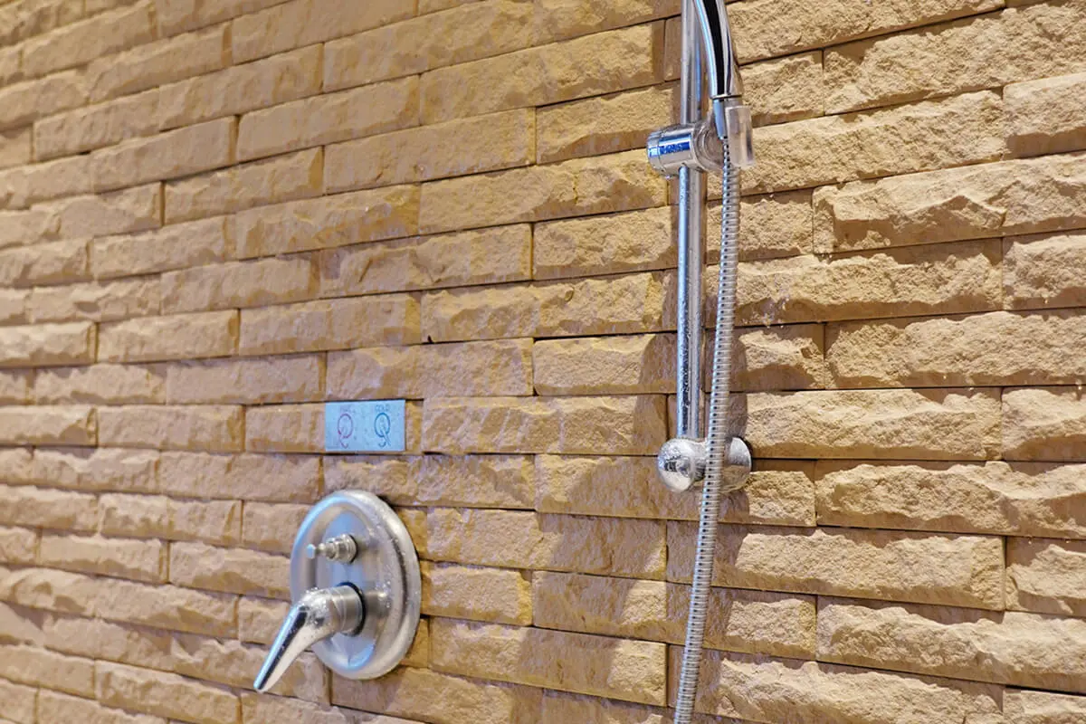 Showerhead on textured stone wall